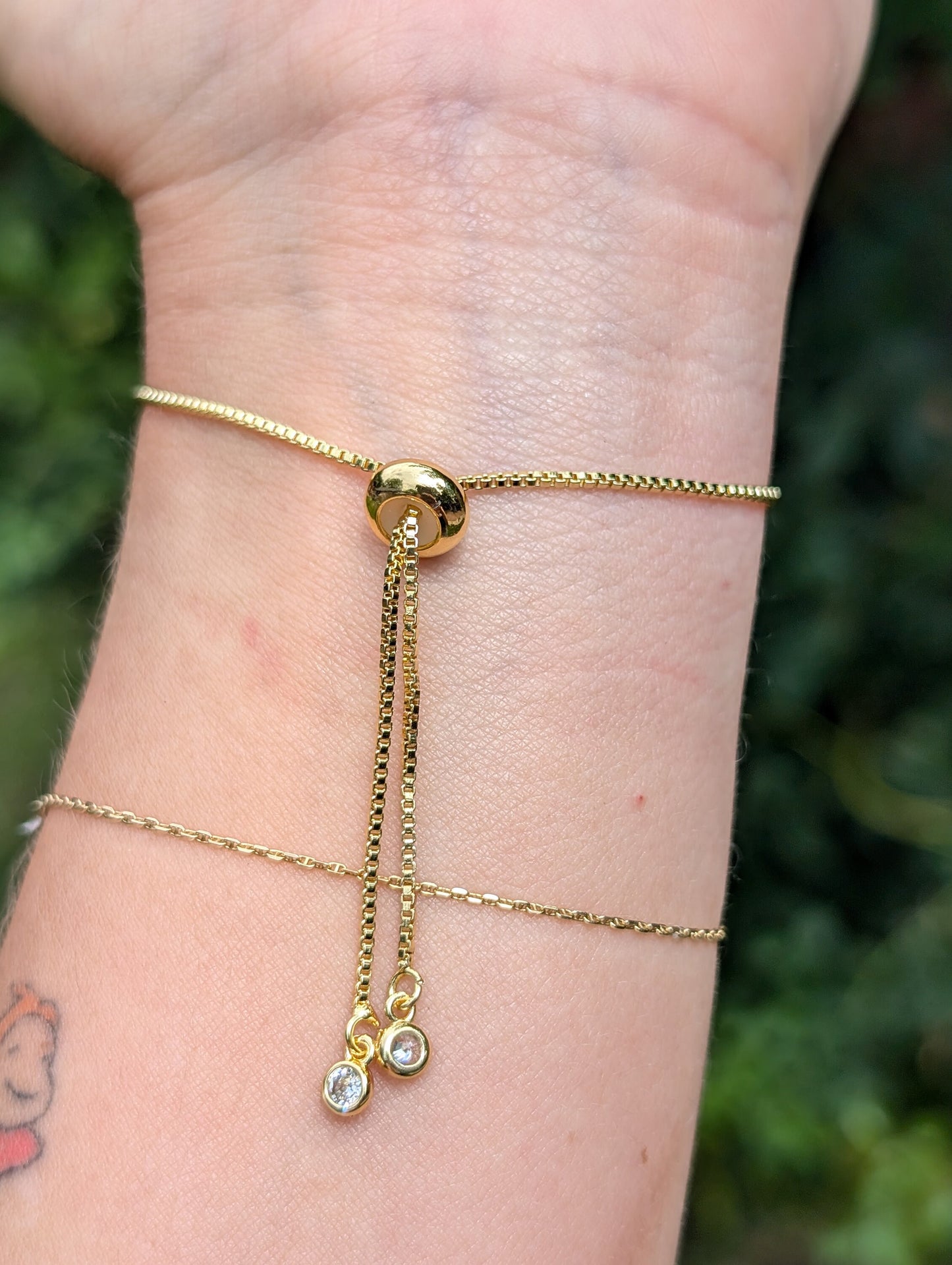 Adjustable gold chain bracelet with two cubic zirconium gem stone drops