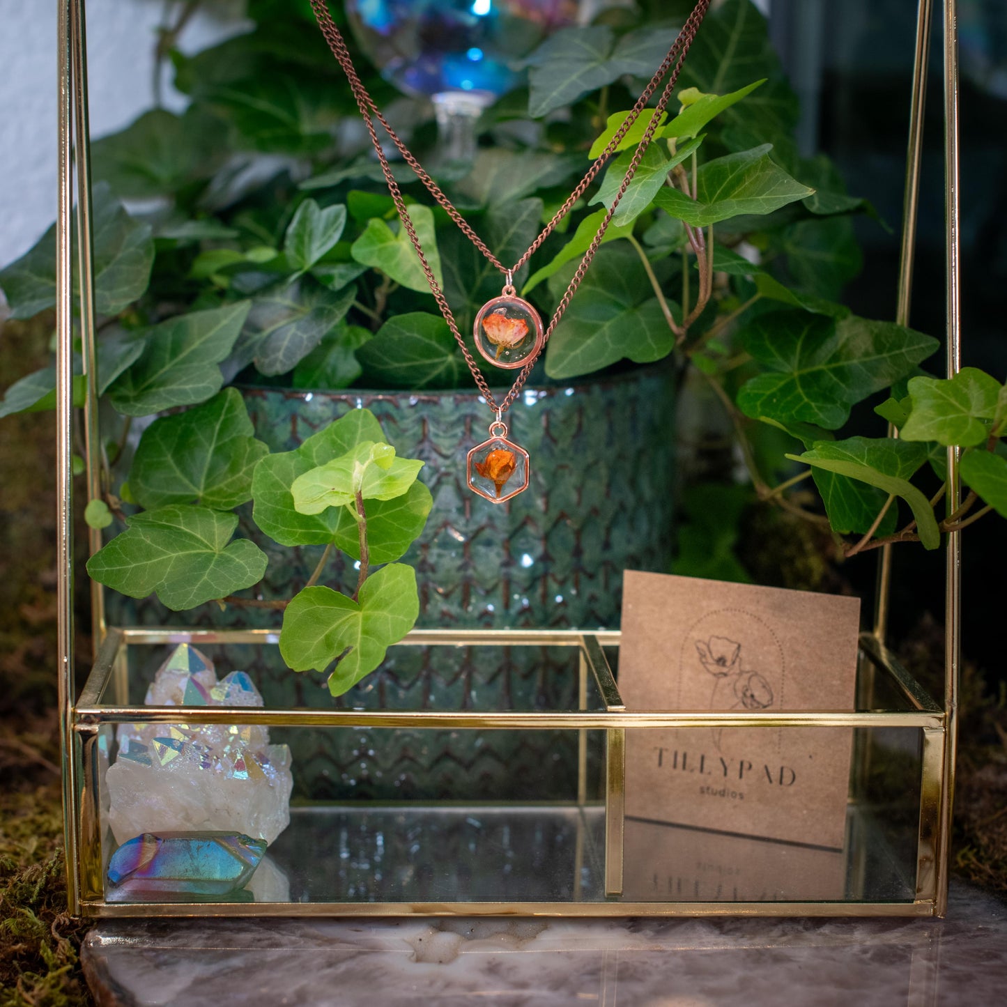 Pressed flower necklace styled on birthday table with cake and candles. Real rose jewelry gift made for birthdays and special milestones.