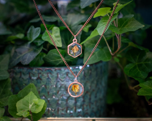A handmade rose pendant necklace featuring a real pressed pink rose preserved in resin, set in a dainty rose gold-toned frame. A romantic and feminine jewelry piece perfect for birthdays, anniversaries, or everyday wear for nature lovers and boho souls.