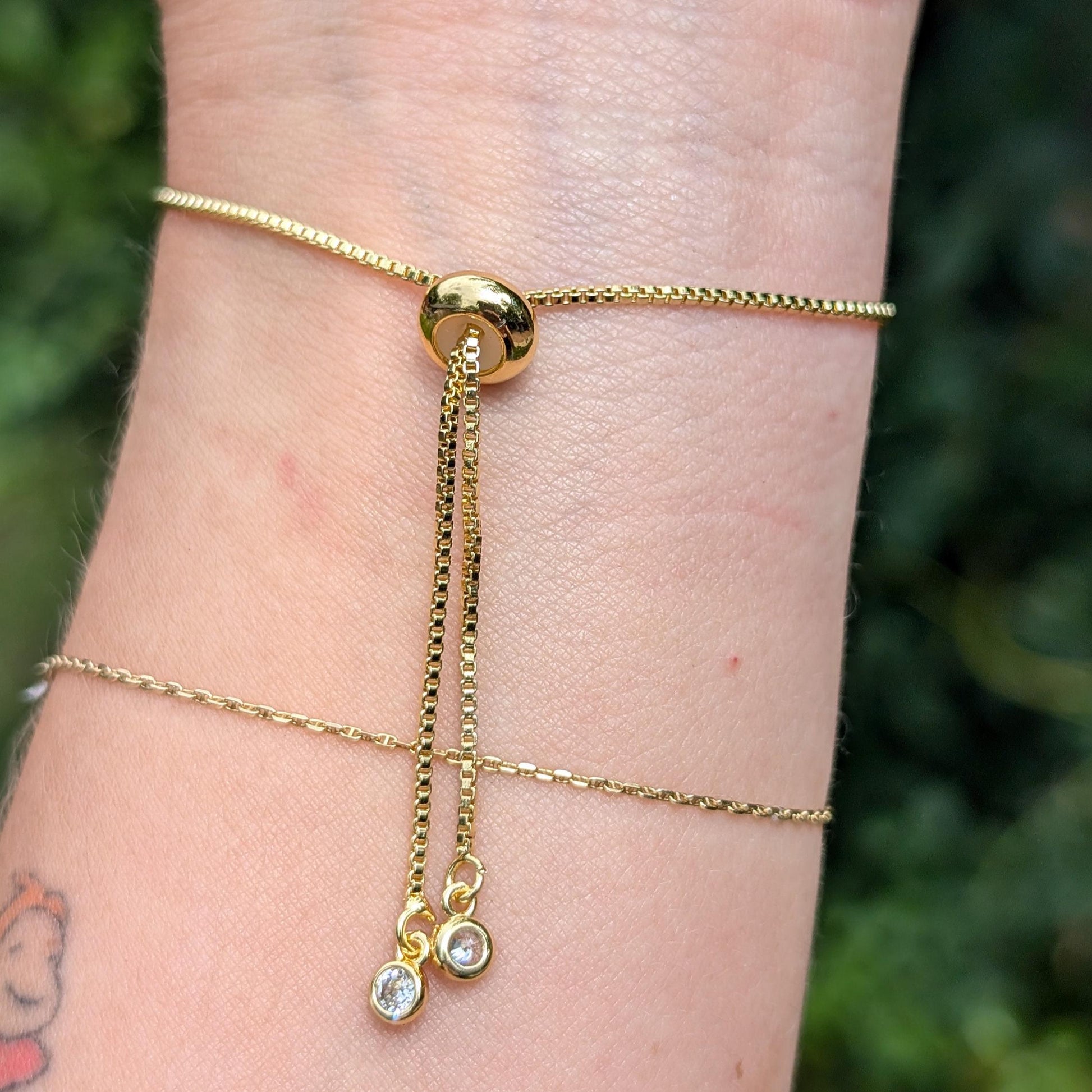 Adjustable gold chain bracelet with two cubic zirconium gem stone drops